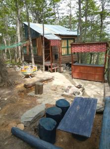 a cabin in the woods with blue logs in front of it at El Isleño in Ushuaia
