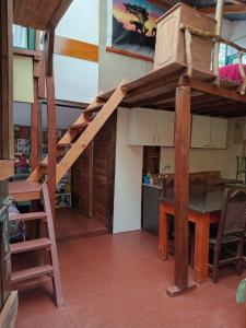 a loft bed in a kitchen with a table and a staircase at El Isleño in Ushuaia