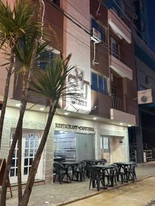a group of picnic tables in front of a building at hotel santa teresita in Santa Teresita