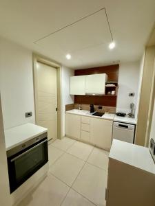 a kitchen with white cabinets and a stove top oven at Suite 419 TQ Plaza in Budva
