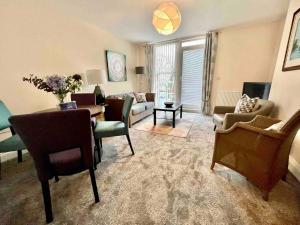 a living room with a couch and a table and chairs at Modern 2 Bedroom Apartment with Sea view in Felixstowe