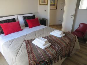 a bedroom with a large bed with towels on it at Ca' di Do in Albissola Marina
