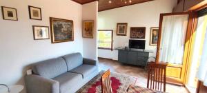 un salon avec un canapé bleu et une télévision dans l'établissement Le Quattro Stagioni, à Massa e Cozzile