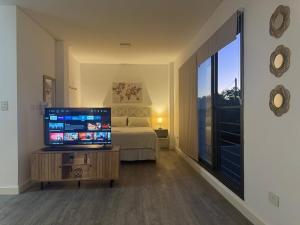 a bedroom with a bed and a television on a table at Campana Suites in Campana