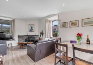 a living room with a couch and a table at Camelot, Newport - A Pembrokeshire Waterside Cottage in Newport Pembrokeshire