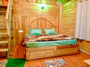 a bedroom with a bed in a wooden room at woodland duplex cottage 2 Jibhi in Jibhi