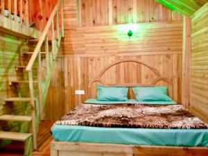 a bedroom with a bed with a wooden wall at woodland duplex cottage 2 Jibhi in Jibhi