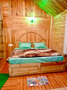 a bedroom with a bed in a wooden room at woodland duplex cottage 2 Jibhi in Jibhi
