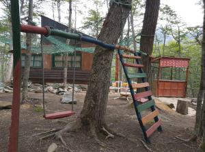 a playground in front of a log cabin at El Isleño in Ushuaia +7 photos
