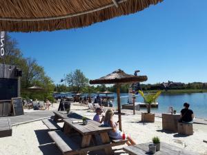 a group of people sitting at picnic tables on the beach at Grosszügige Wohnung für 4 Personen in Ostfriesland mit E- Ladesäule in Utarp