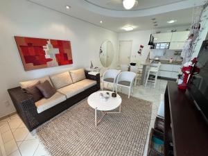 a living room with a couch and a table at Ap Completo /Ar e Wi-Fi/ Riviera in Riviera de São Lourenço