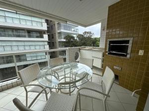 a glass table and chairs on a balcony at Ap Completo /Ar e Wi-Fi/ Riviera in Riviera de São Lourenço
