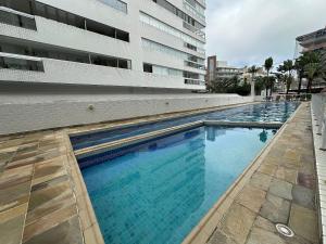 a large swimming pool next to a building at Ap Completo /Ar e Wi-Fi/ Riviera in Riviera de São Lourenço