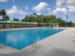 a pool at a resort with chairs and a windmill at Apart Hotel City Bell in City Bell