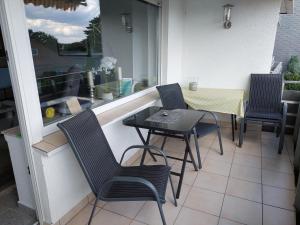 a balcony with a table and chairs and a window at Ferienwohnung Sander mit Innenpool in Möhnesee +4 photos