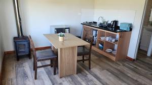 a kitchen with a wooden table and a stove at Spa, piscina y cabañas Tierra Mar in La Montaña