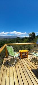 a chair and a table on a wooden deck at Ventana al Champaqui in Yacanto