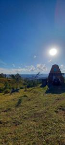 a barn in the middle of a grassy field at Ventana al Champaqui in Yacanto