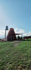 a barn with a silo in a field at Ventana al Champaqui in Yacanto