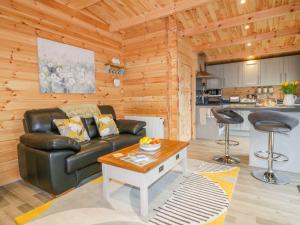 a living room with a leather couch and a table at Little Orchard Lodge in Truro +12 photos