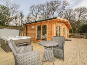 a small cabin with a table and chairs on a deck at Little Orchard Lodge in Truro