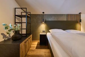 a bedroom with a large white bed and a shelf at MiLa Apartments in Saalbach Hinterglemm +115 photos