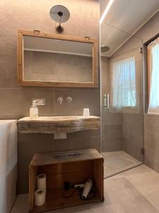 ein Badezimmer mit Waschbecken und Spiegel in der Unterkunft Appartamento TEMELIN in Bormio