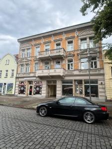 a black car parked in front of a building at Five O - Die Suite- Watzlawick - 2 Schlafzimmer in Wittenberge