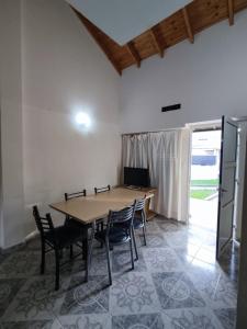 Un comedor con mesa y sillas de madera. en Perik Termas, en Colón 12 fotos más