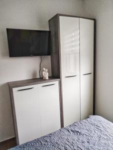 a bedroom with a white cabinet and a bed at Moj Mir in Vrnjačka Banja