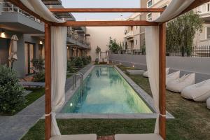 an outdoor swimming pool with a pergola at NEK Suites - Adults Only in Chania Town