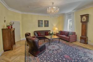 a living room with couches and a table and a clock at Holiday Berlin Apartments in Berlin