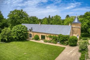 an old stone house with a large yard at Le Domaine des Ormeaux in Saint-Alvère