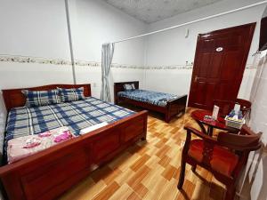 a bedroom with a bed and a table and a chair at Nhà nghỉ Thế Phú in Trà Vinh