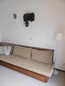 a couch in a living room with a stuffed elephant on the wall at Avanta in Ban Mae Nam