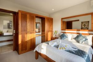 a bedroom with a large bed with a wooden headboard at Echo Beach Townhouses in Canggu