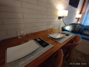 a wooden table with wine glasses and a plate on it at Erdgeschosswohnung im historischen Fachwerkhaus in Alsfeld inklusive PKW-Parkplatz in Alsfeld +1 photo
