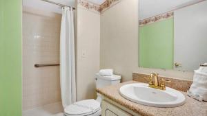 a bathroom with a sink and a toilet and a shower at Relaxing Ocean Condo Steps from the Beach in Daytona Beach Shores