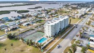 an aerial view of a white building with a tennis court at Relaxing Ocean Condo Steps from the Beach in Daytona Beach Shores