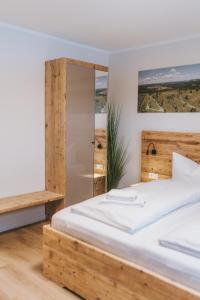 ein Schlafzimmer mit einem Bett mit einem hölzernen Kopfteil in der Unterkunft Ferienwohnung Schneeglück für 10 Personen in Winterberg