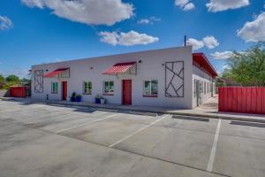 a white building with red doors and a parking lot at Game Day Hub! 1 Mi to AU and Arizona Stadium in Tucson