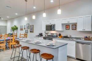 a kitchen with white cabinets and a counter with stools at Game Day Hub! 1 Mi to AU and Arizona Stadium in Tucson