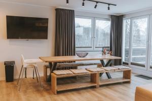ein Wohnzimmer mit einem Holztisch, einem Tisch und Stühlen in der Unterkunft Ferienwohnung Schneeglück für 10 Personen in Winterberg