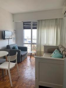 Piso 24 vista al Obelisco في بوينس آيرس: غرفة معيشة بها أريكة وطاولة