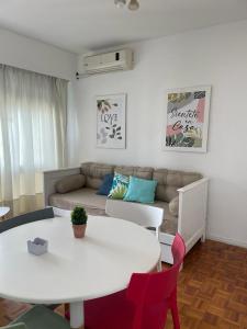 Piso 24 vista al Obelisco في بوينس آيرس: غرفة معيشة مع طاولة بيضاء وأريكة