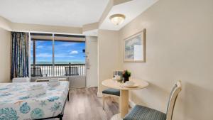 a room with a bed and a table and a window at Daytona Beach Getaway with Direct Ocean Views in Daytona Beach