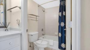 a white bathroom with a toilet and a shower at Daytona Beach Getaway with Direct Ocean Views in Daytona Beach