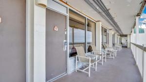 a corridor with chairs and tables on a building at Daytona Beach Getaway with Direct Ocean Views in Daytona Beach