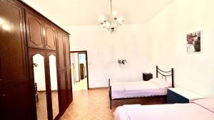 Appartamento Camere Vacanze Debora في بوريتا تيرمي: غرفة نوم بها سريرين وثريا