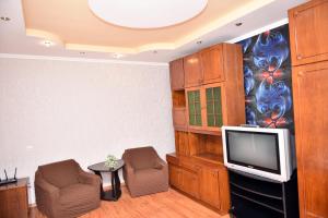 a living room with a tv and two chairs at Двокімнатна квартира, Харківська, 25 in Sumy